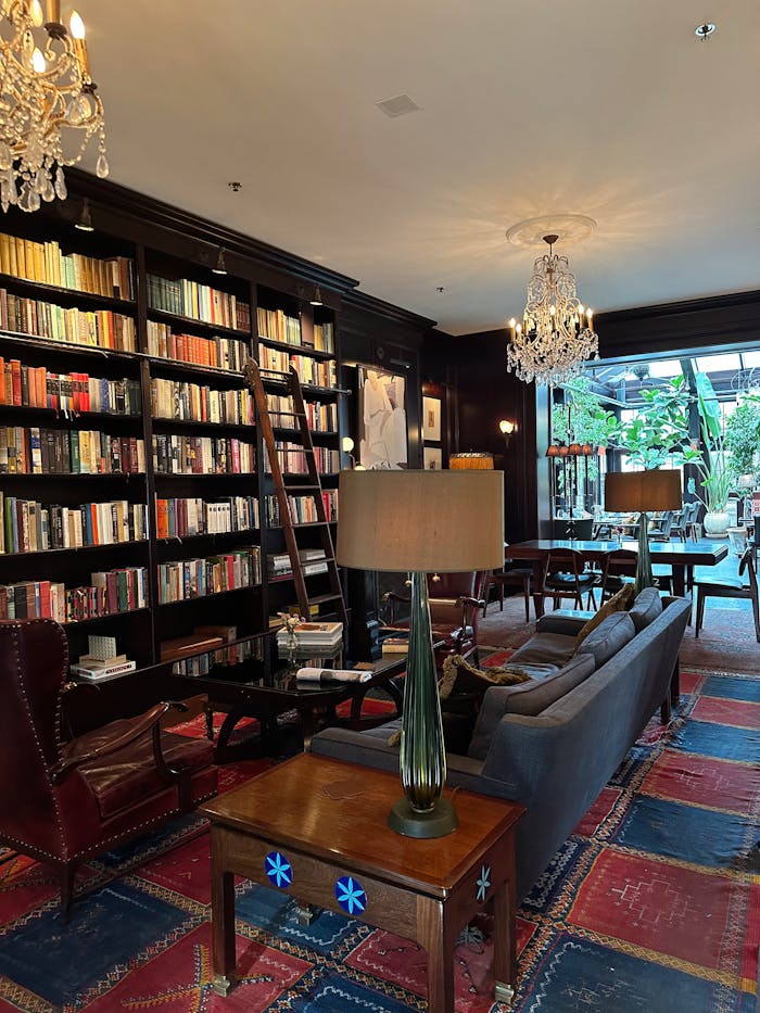 Elegant library with bookshelves and seating in Hudson, NY boutique hotel.
